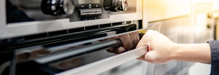 Hand öffnet Backofentür